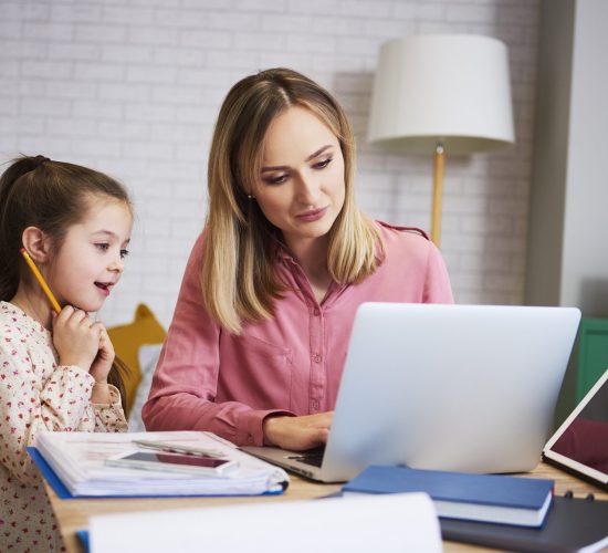 Young mother working from home with daughter