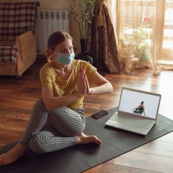 sporty-young-woman-taking-yoga-lessons-online-practice-home-while-being-quarantine